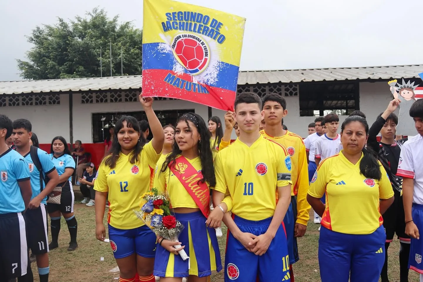 Equipo estudiantil amarillo presenta su estandarte durante las olimpiadas deportivas